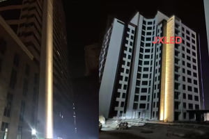 Diagram showing light from a narrow beam reaching the top of a skyscraper