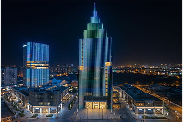 A brightly illuminated skyscraper facade at night using linear lights