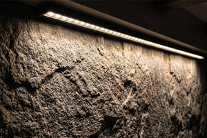 Light washing over a rough, matte stone wall surface